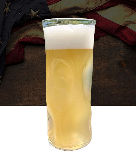 A glass of pale beer with foam, American flag, wood background at Bog’s Edge Brewing Company.